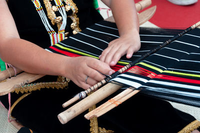 Midsection of woman playing with chopsticks