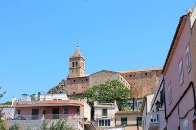 Low angle view of buildings against clear blue sky