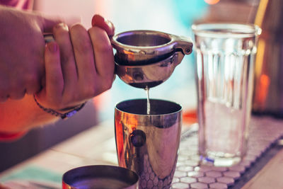 Close-up of hand pouring drink in glass