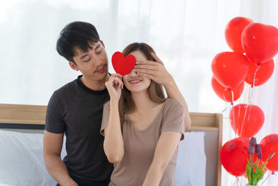 Rear view of two women holding balloons