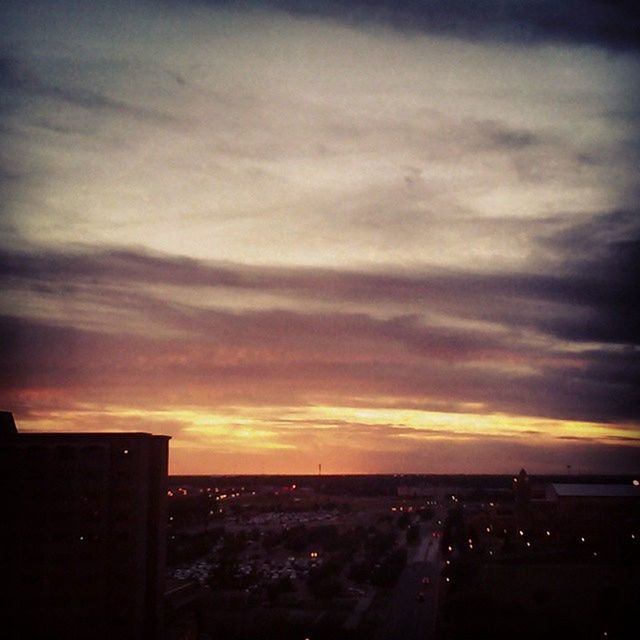 sunset, building exterior, sky, cityscape, city, architecture, built structure, cloud - sky, orange color, high angle view, dusk, illuminated, silhouette, dramatic sky, residential district, cloud, cloudy, residential building, residential structure, outdoors