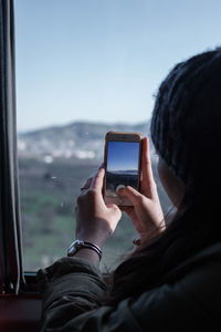 Midsection of man photographing with mobile phone