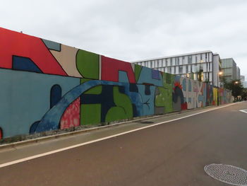 Graffiti on modern city street against sky