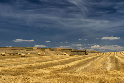 Hay bales on field against sky