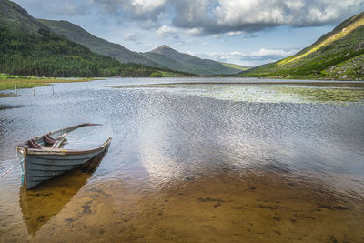 Sunken or submerged paddle boat in lough gummeenduff with view on beautiful black valley, ireland