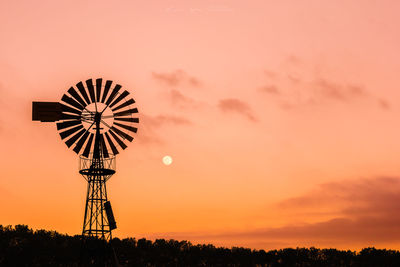 Silhouette windmill against sky during sunset