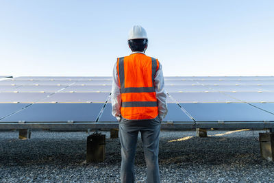 Rear view of man working against sky