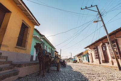 Low angle view of buildings by street against sky