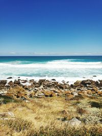 Scenic view of sea against clear blue sky