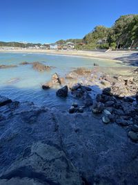 Rocks on beach against clear blue sky