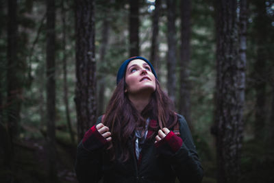 Portrait of young woman standing in forest