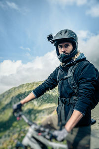 Man riding bicycle on mountain against sky