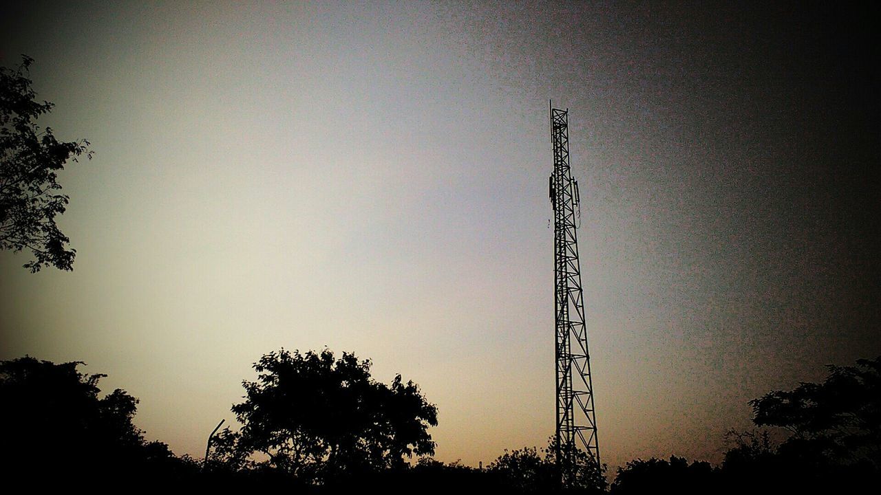 low angle view, silhouette, tree, sunset, sky, electricity, fuel and power generation, electricity pylon, dusk, technology, clear sky, connection, power line, nature, power supply, copy space, tall - high, outdoors, no people, growth