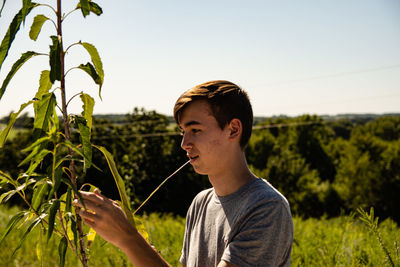 Portrait of boy on field against sky