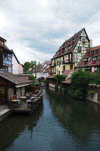 Canal amidst buildings against sky