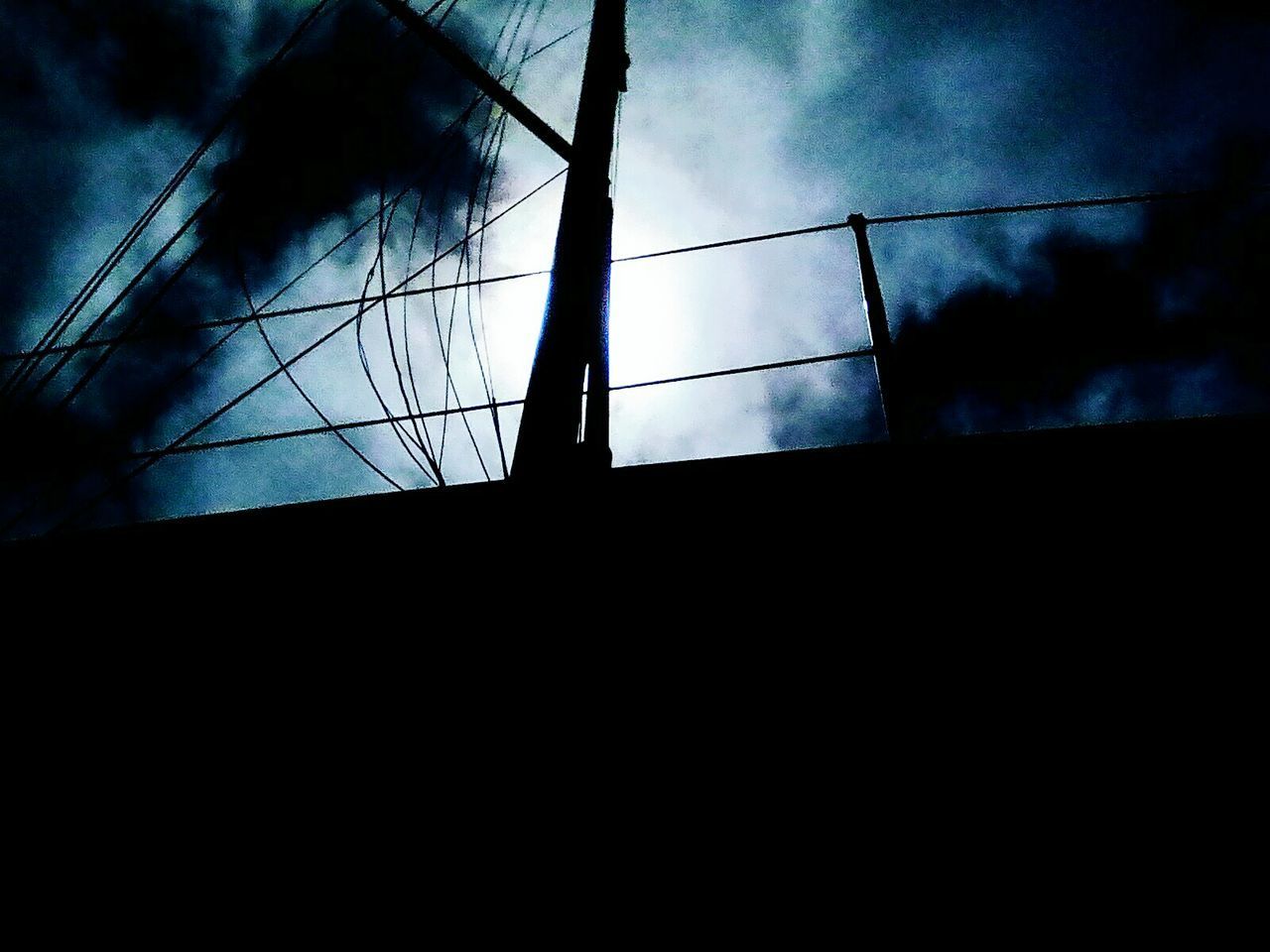 SILHOUETTE OF ELECTRICITY PYLON AGAINST SKY