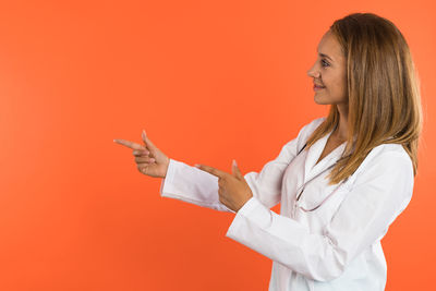 Young woman with arms crossed against yellow background