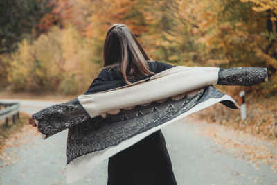 Rear view of woman standing against trees