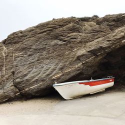 Boat moored on shore against sky