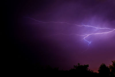 Low angle view of thunderstorm on cloudy sky at dusk