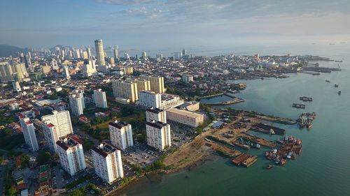 High angle view of buildings by sea against sky