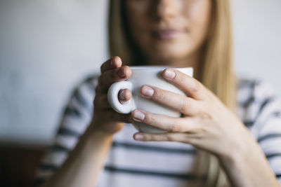 Midsection of woman holding coffee cup