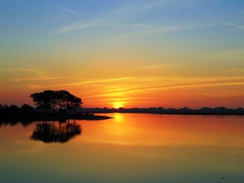 Scenic view of lake against orange sky