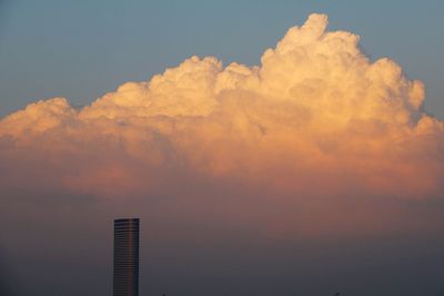 Low angle view of buildings against cloudy sky during sunset