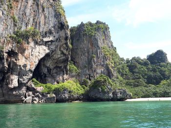 Rock formations by sea against sky