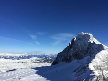 Scenic view of snowcapped mountains against blue sky