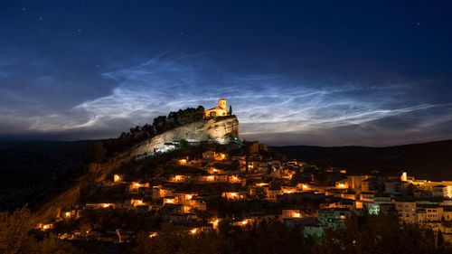 Illuminated buildings against sky at night