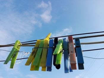 Low angle view of clothespins hanging on clothesline