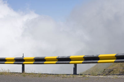 Yellow umbrella on wet land against sky