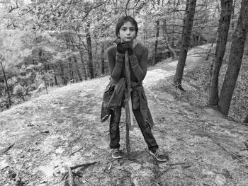 Portrait of young woman standing in forest