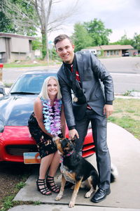 Full length of woman with dog standing by car