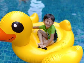 Full length of boy playing with toy in swimming pool