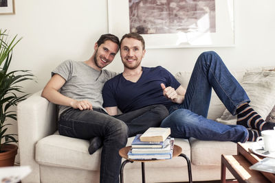 Portrait of homosexual couple sitting together on sofa at home