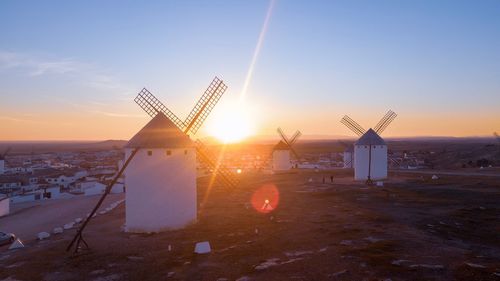 Traditional windmill against sky during sunset