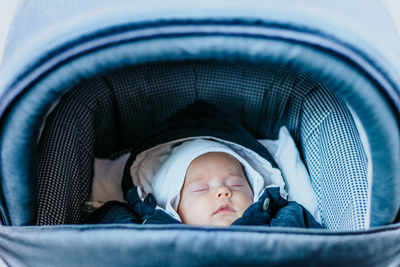 Close-up of baby sleeping in baby carriage