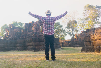 Rear view of man standing on stone structure