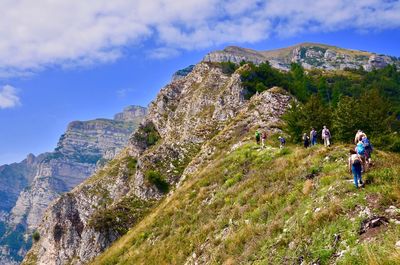 Rear view of people on mountain against sky