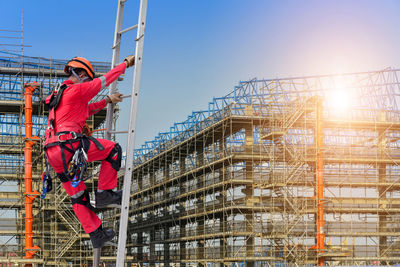 Man working at construction site against sky