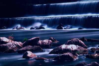 Scenic view of waterfall by sea