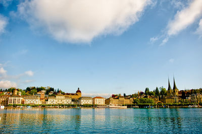 View of town by river against sky