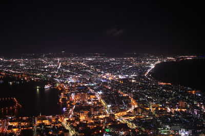 High angle view of illuminated cityscape against sky at night