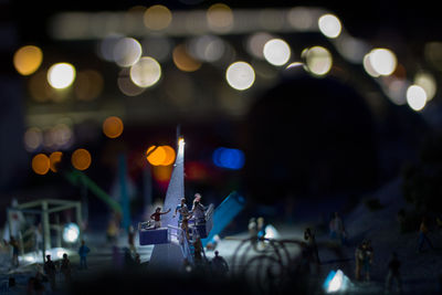 Tilt shift of human figurine on beach at night