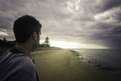 Close-up of man at beach against sky