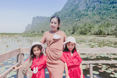 Mon and two cute little girls standing in bridge