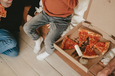 Snack on pepperoni pizza, out of the box on the floor, top view. pizza box and round knife 