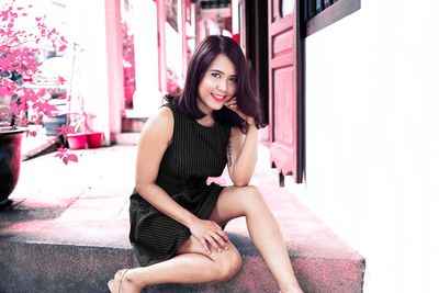 Portrait of smiling young woman sitting outdoors